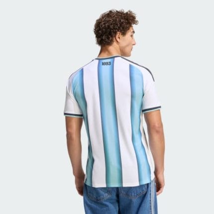 Camiseta titular de Argentina 2026 para adulto. Diseño oficial albiceleste con el escudo de la AFA y las tres estrellas de campeón.