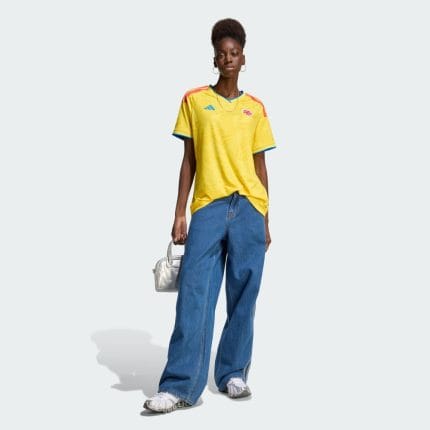 Camiseta primera equipación de la Selección Colombia para mujer, versión 2026. Uniforme oficial amarillo para aficionadas.