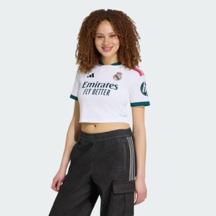 Camiseta de mujer Real Madrid 2027 primera equipación, corte corto por encima de la cintura, diseño deportivo oficial.