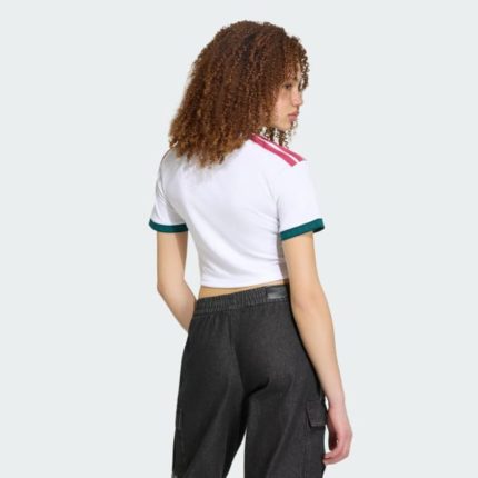 Camiseta de mujer Real Madrid 2027 primera equipación, corte corto por encima de la cintura, diseño deportivo oficial.
