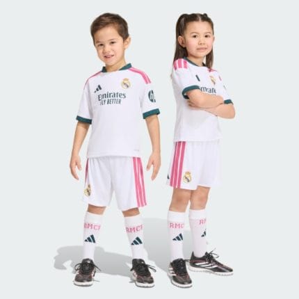 Primera equipación para niño del Real Madrid temporada 2027. Conjunto completo de camiseta y pantalón corto blancos oficiales.