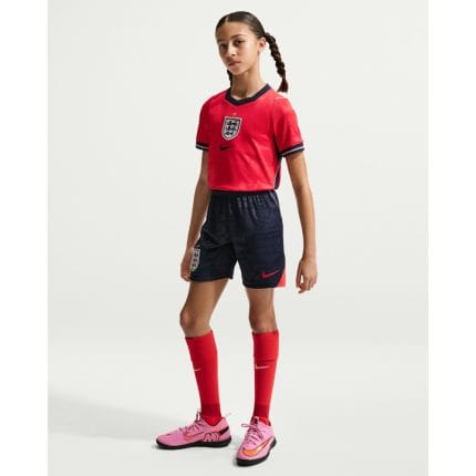 Segunda equipación de fútbol roja para niño de Inglaterra 2026. Conjunto oficial para los pequeños aficionados de la selección.