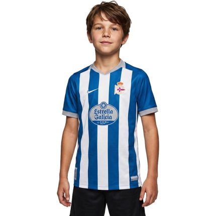 Primera equipación del Deportivo de La Coruña para niños temporada 26-27. Conjunto oficial de camiseta y pantalón blanquiazul.