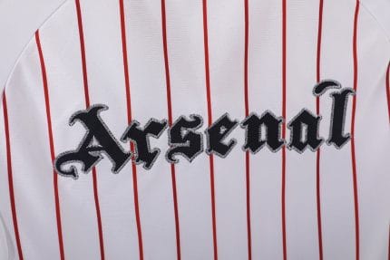 Camiseta retro Arsenal 1988 estilo béisbol, blanca con rayas rojas, logo Adidas moderno y escudo 'A' fantasía. — foto 2