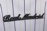 Camiseta estilo béisbol del Real Madrid, diseño blanco con rayas y detalles en negro y verde lima, con el escudo del club. — foto 2