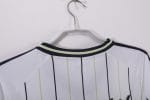 Camiseta estilo béisbol del Real Madrid, diseño blanco con rayas y detalles en negro y verde lima, con el escudo del club. — foto 3