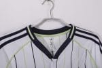 Camiseta estilo béisbol del Real Madrid, diseño blanco con rayas y detalles en negro y verde lima, con el escudo del club. — foto 12
