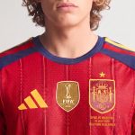 Detalle del escudo con una estrella en la primera equipación de la camiseta de España para adulto de la final del Mundial 2026.