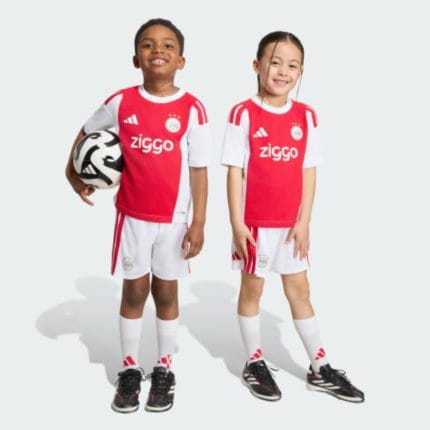 Primera equipación de fútbol para niños del Ajax de la temporada 2026/2027. Conjunto de camiseta y pantalón corto oficial.