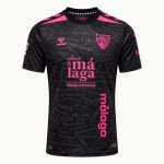 Vista frontal de la camiseta alternativa del Málaga CF para la temporada 2026/27, con escudo del club y logos de patrocinadores.