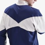 Vista frontal de la chaqueta cortavientos del Tottenham Hotspur 26/27 para adulto. Escudo del club y logos patrocinadores.